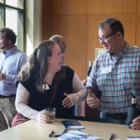 Two event attendees standing at table in conversation with each other